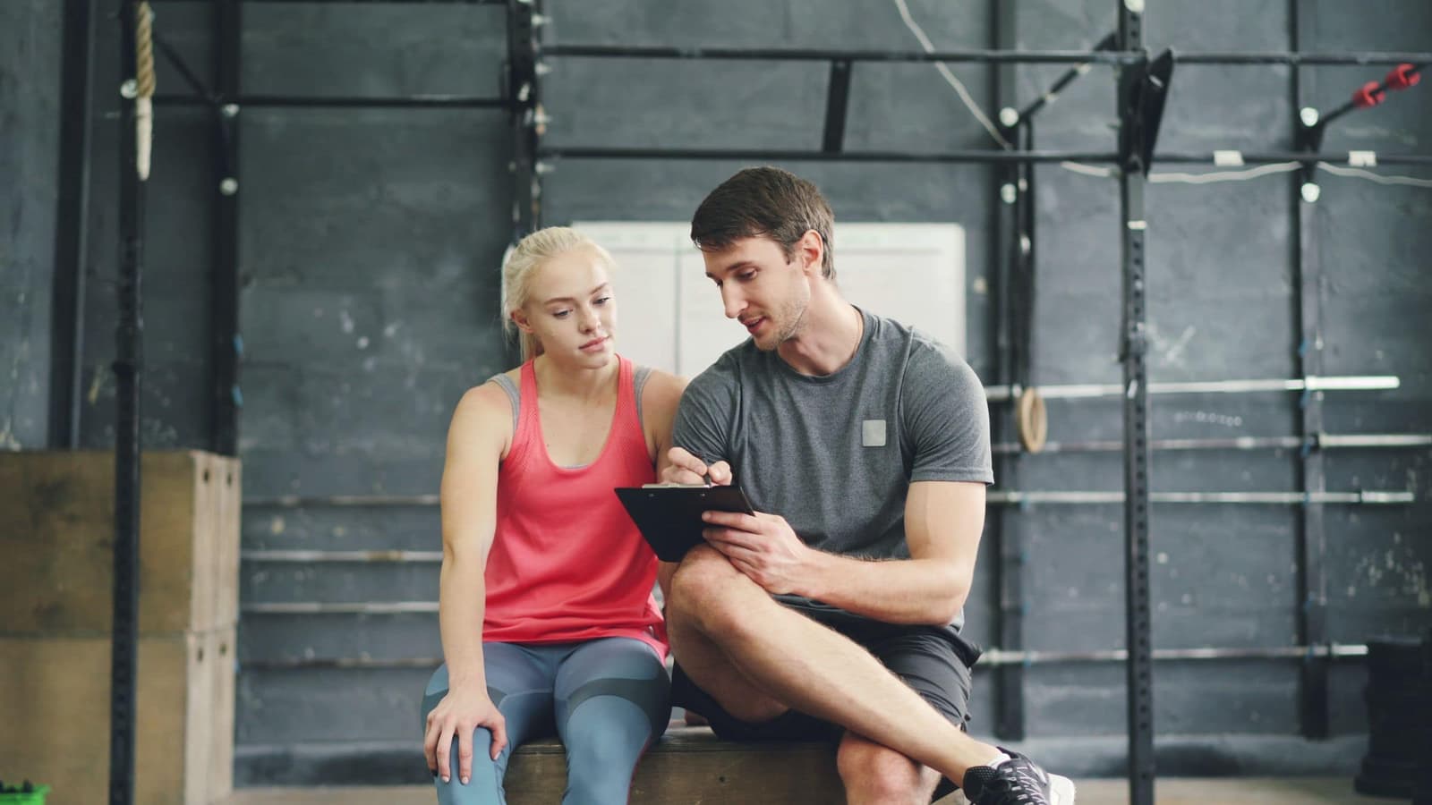A coach and client reviewing a written plan on a tablet